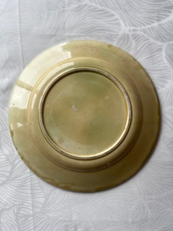 Onderzijde van een antiek barbotine bord van 21 cm met zichtbaar craquelé en authentieke afwerking.