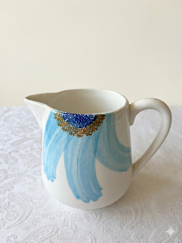 Gien Marguerite blauwe schenkkan op een wit linnen tafelkleed.